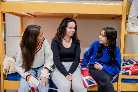 3 jeunes filles de l'internat en train d'échanger dans une chambre