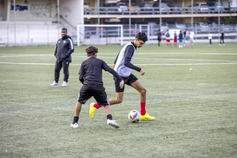 Deux jeunes en train de jouer au football sur un terrain lors d'une séance d'entraînement de la section foot