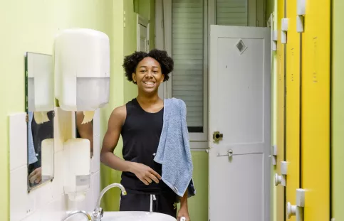 Un jeune homme qui sourit dans les douches de l'internant de Vitagliano à Marseille