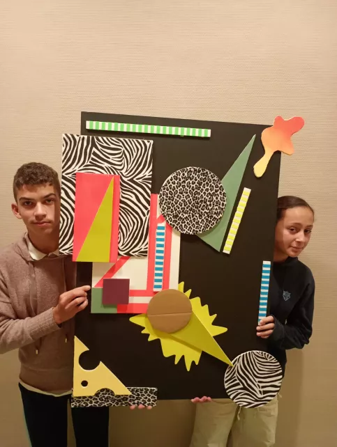 Deux jeunes qui montrent leur oeuvre 