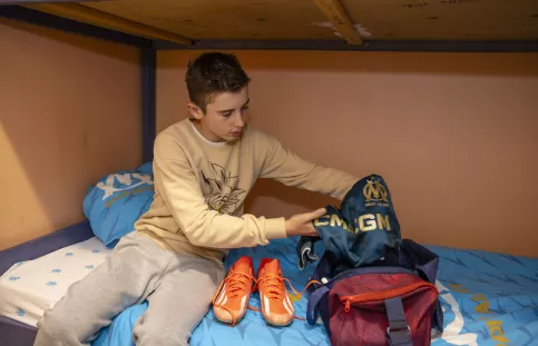 Un jeune de l'internat qui prépare son sac pour son entrainement de foot dans sa chambre de l'internat