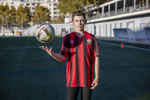 Portait de Léo, jeune du collège Vitagliano avec un ballon de foot dans la main et son maillot du club de foot de Vitagliano au stade Vallier