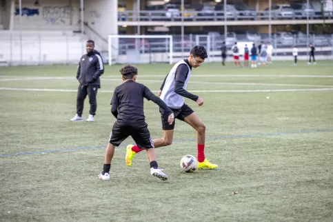 Deux jeunes en train de jouer au football sur un terrain lors d'une séance d'entraînement de la section foot