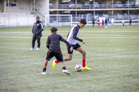 Deux jeunes en train de jouer au football sur un terrain lors d'une séance d'entraînement de la section foot