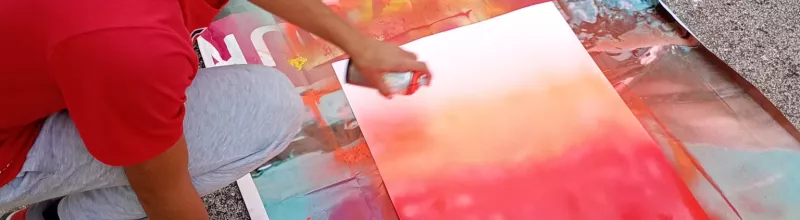 Jeune en train de faire de la peinture à la bombe sur une toile