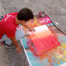 Jeune en train de faire de la peinture à la bombe sur une toile
