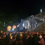 pelerins avec des torches illuminsées devant un monument embléùatique de Lourdes
